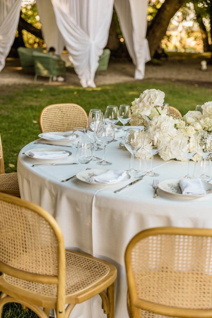 In questa foto il dettaglio di un tavolo matrimonio allestito con fiori Total White per uno Small Wedding nel giardino di Villa Ormaneto