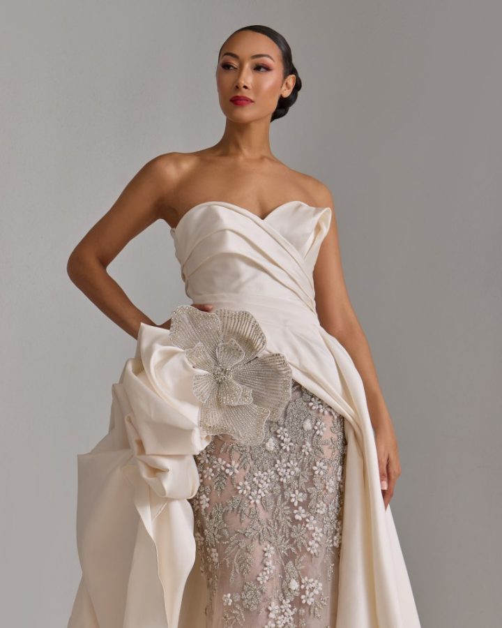 in questa foto si vede un abito in cui sono raccolte tutte le tendenze sposa per il 2026. Dal layering di tessuti fino al drappeggio, passando per i fiori 3D. Un abito scultoreo che valorizza la figura femminile con un tocco di estro che mette al centro la personalità della sposa 