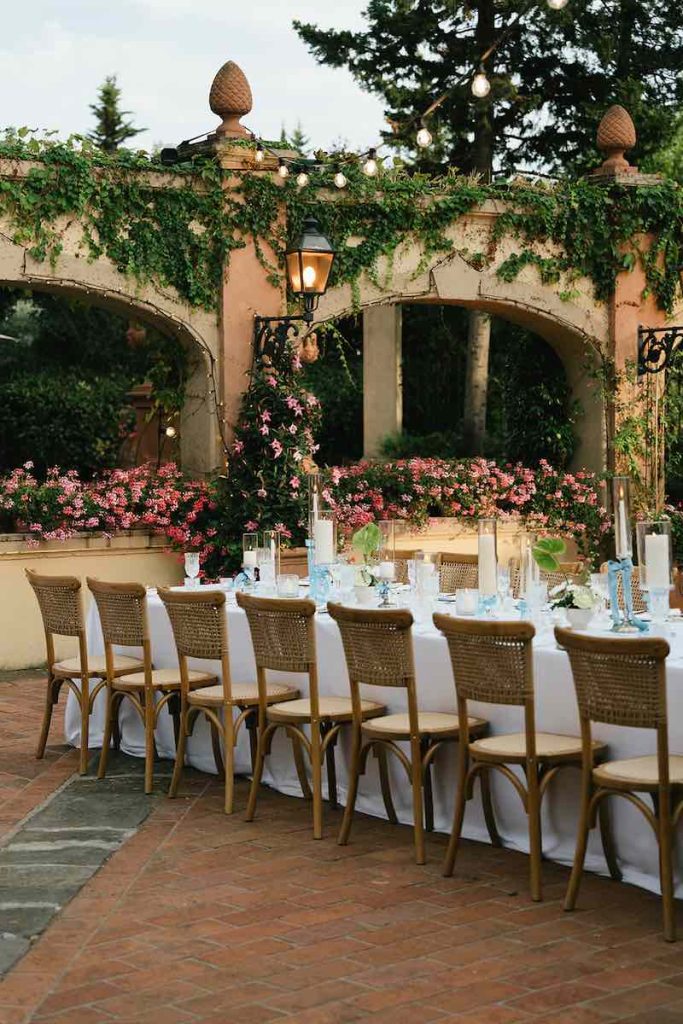 In questa foto il dettaglio uno dei matrimoni su misura firmati da The Couplers: un tavolo imperiale allestito con candele bianche, fiocchi di colore turchese e piatti d'argento
