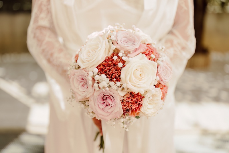 In questa foto, il dettaglio di un bouquet rotondo con rose di colore bianco e rosa 