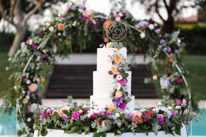 In questa foto un torta per matrimonio decorata da Ada Di Donato con fiori di colore rosa, turchese, viola e fucsia
