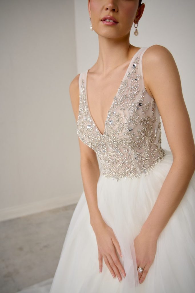 In questa foto, il dettaglio di un abito della collezione sposa Justin Alexander Signature P/E 2026 con corpetto ricamato con perline e cristalli e scollo a V