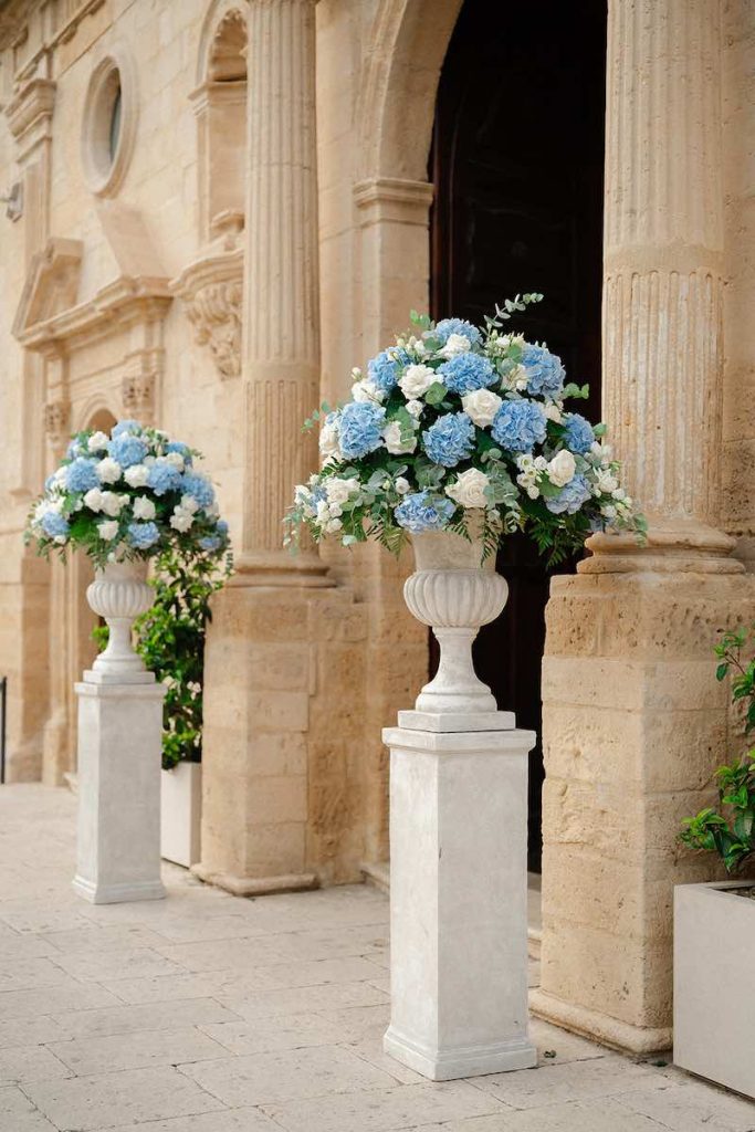 In questa foto, l'ingresso della Chiesa di San Rocco di Scordia allestita da Panta Rhei con vasi di ortensie di colore azzurro e rose di colore bianco