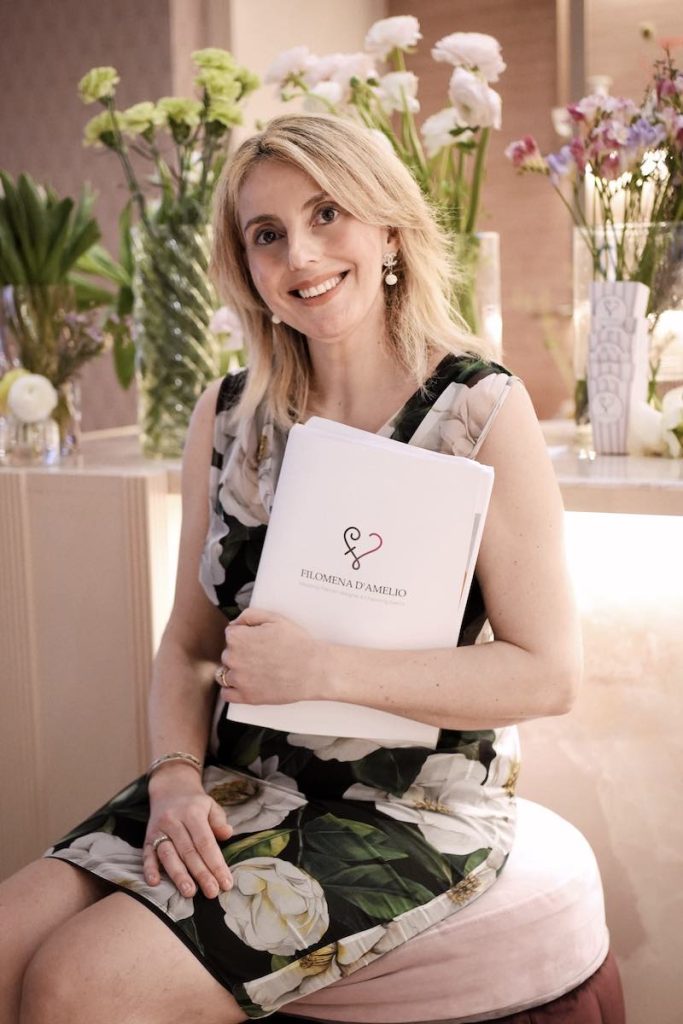 In questa foto la Wedding Planner Filomena D'Amelio posa seduta davanti all'allestimento di un matrimonio