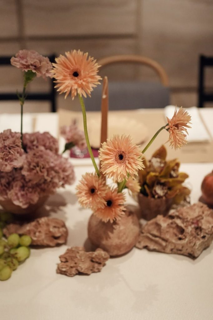 In questa foto il dettaglio di una decorazione per matrimonio con fiori di colore rosa e melagrane
