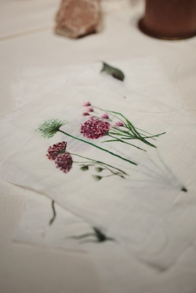 In questa foto il dettaglio di un tovagliolo dipinto con un disegno di fiori