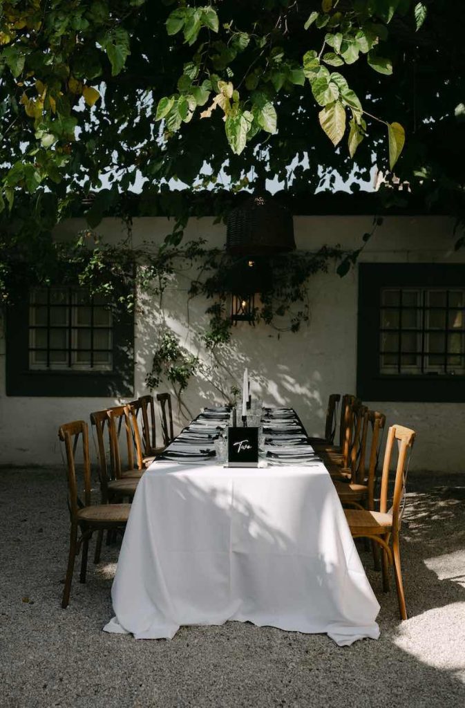 In questa foto un tavolo imperiale allestito sotto ad un albero, nei toni bianco e nero