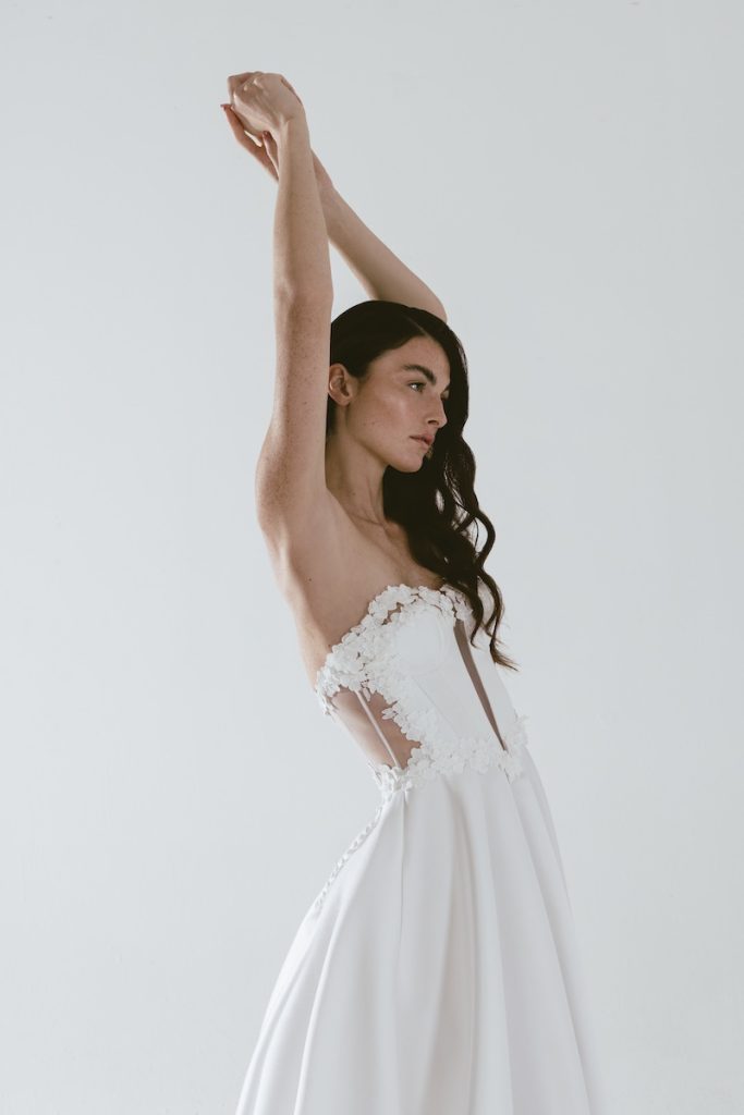 In questa foto una modella indossa un abito scivolato della linea Futura by Luisa Lotti con corpetto effetto cut out e inserti di fiori 3D 