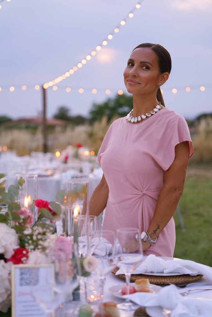In questa foto, la Wedding Planner Manuela Marrale posa davanti ad uno dei tavoli allestiti per il matrimonio di Flavia e Federico