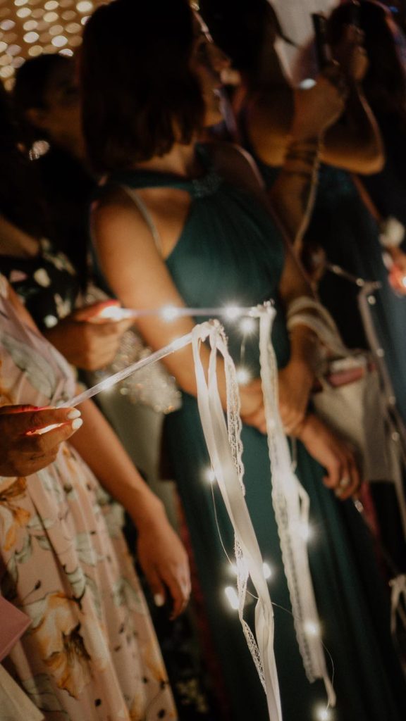 In questa foto nastri di stoffa e di luci tenuti dagli ospiti durante un party di nozze