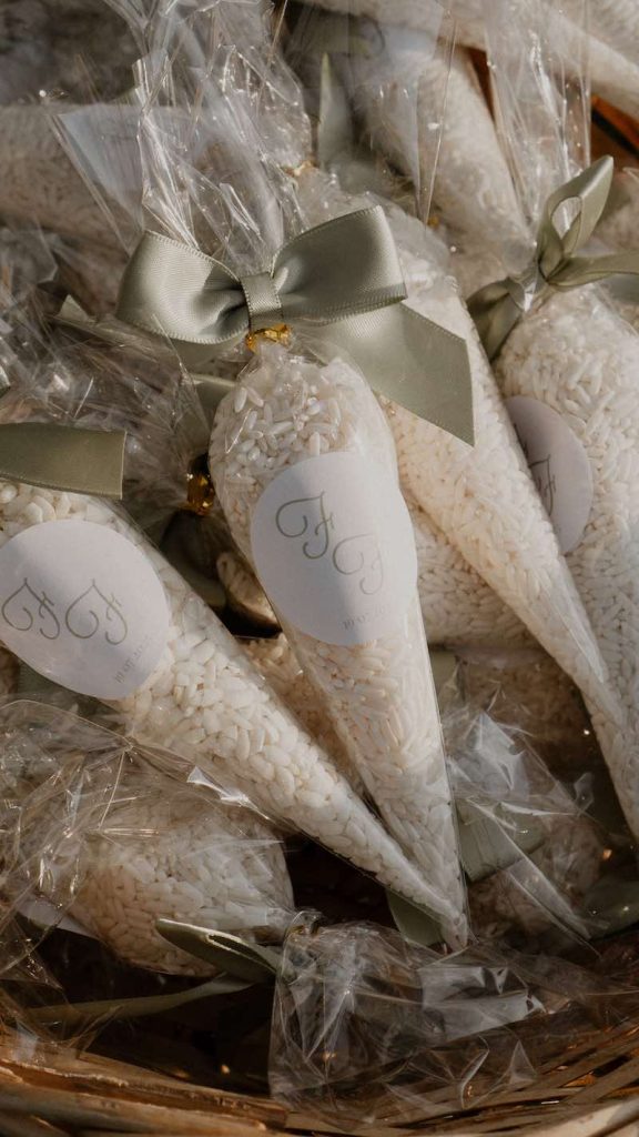 In questa foto conetti portariso in pacchetti trasparenti decorati con un adesivo con logo e nastro di di colore verde