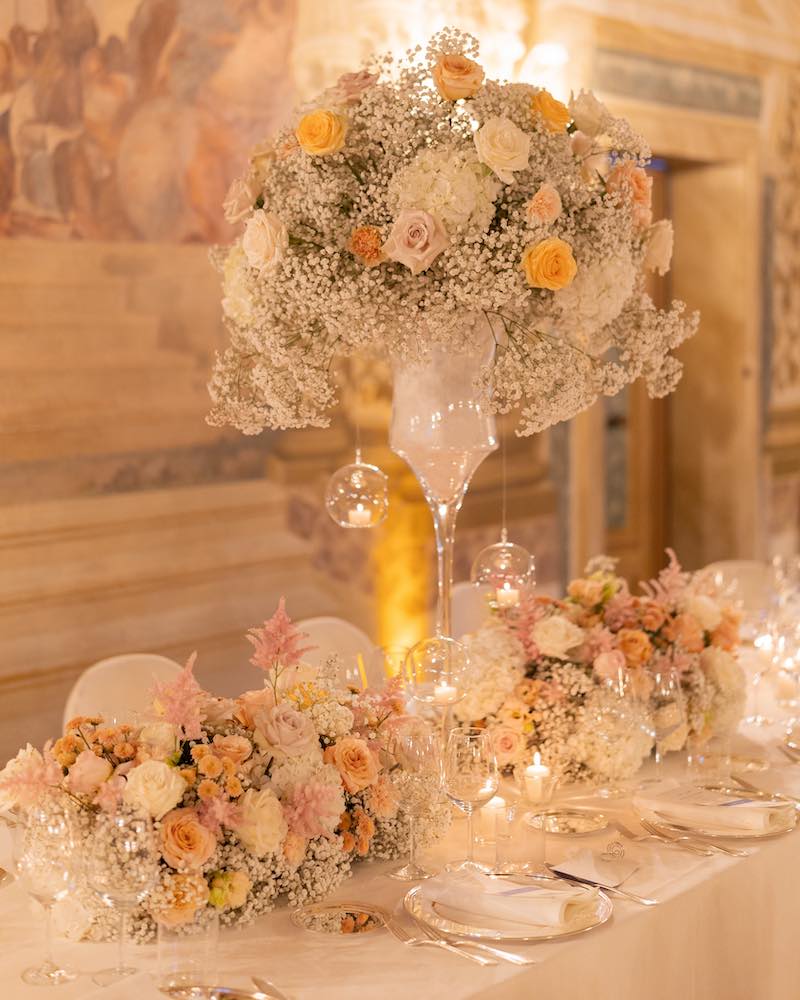In questa foto il dettaglio di un allestimento di un tavolo per matrimonio decorato da Silvia Baldan con alzate di fiori di colore bianco e rosa e candele 