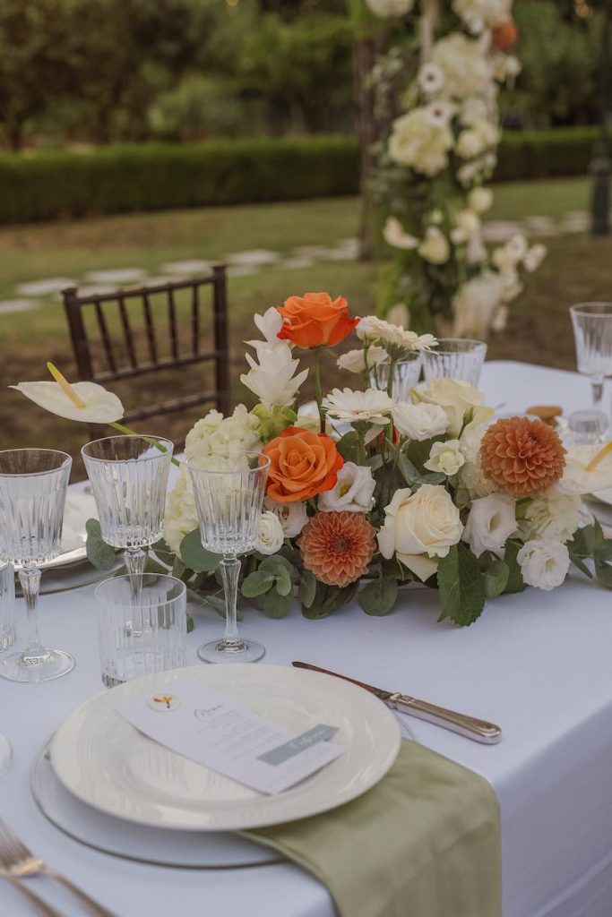 In questa foto una mise en place nello stile di Tatiana Tabanelli nei toni del bianco e arancio realizzata per un matrimonio