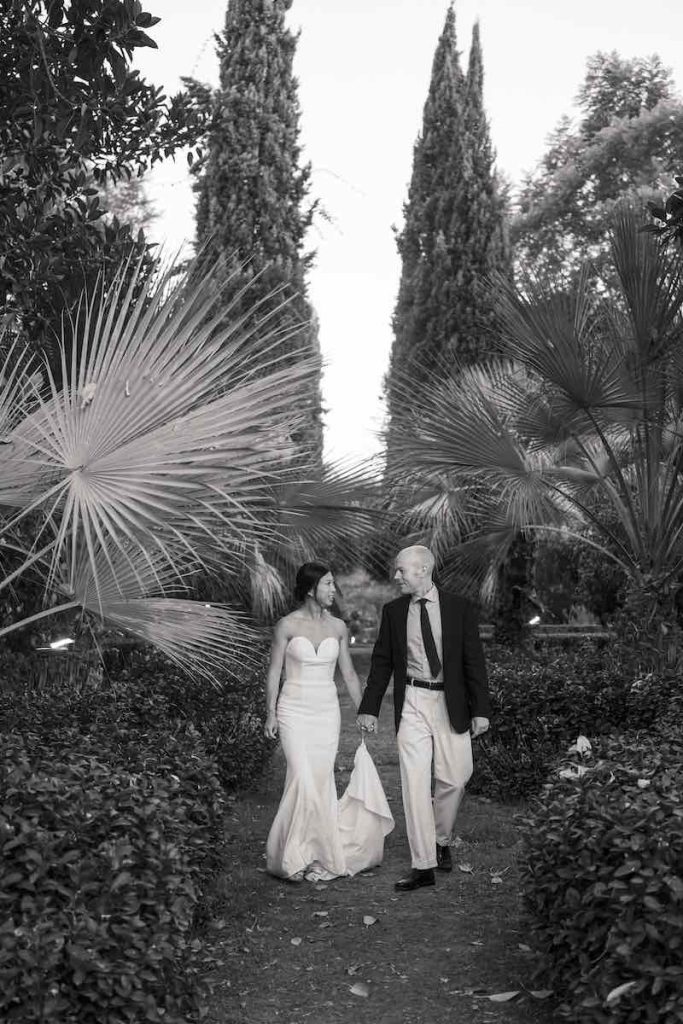 In questa foto in bianco e nero due sposi camminano in giardino