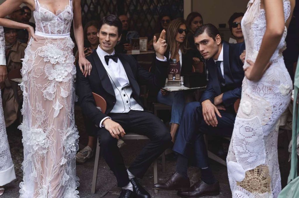 In questa foto modelle e modelli in abiti da sposa e sposo posano in un caffè di Milano