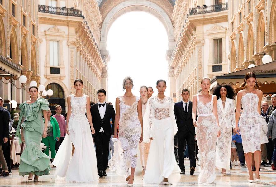 In questa foto alcune modelle in abiti da sposa sfilano nella galleria del Duomo di Milano per il Sì Sposaitalia Collezioni