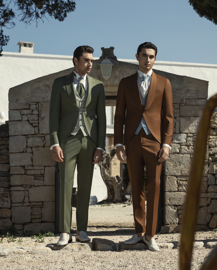 In questa foto due modelli vestiti con abiti nelle tonalità pop del verde e del marrone delle collezioni sposo Andrea Versali.