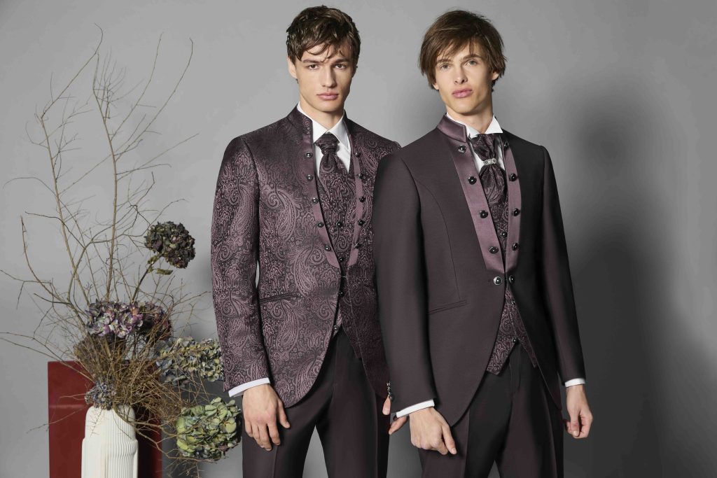 In questa foto due modelli indossano abiti Luigi bianchi nelle tonalità del bordeaux con motivi damascati.