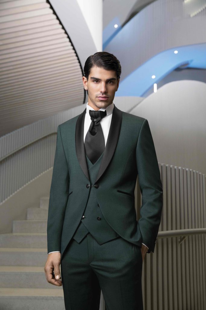 In questa foto un abito verde bosco con revers a contrasti neri, una tendenza sposo 2026, che fa parte della collezione di Pisconti.