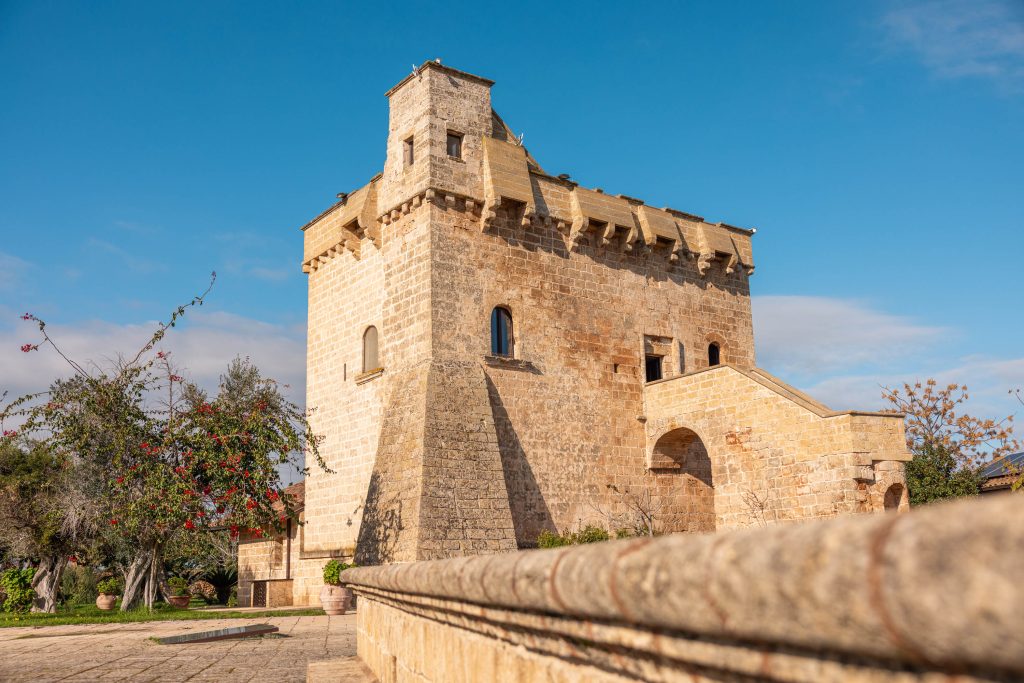 In questa foto si vede uno degli spazi di un matrimonio a a Tenuta Monacelli, una torre storica in pietra vista dall’esterno, elemento architettonico simbolo della tenuta immerso nel verde.