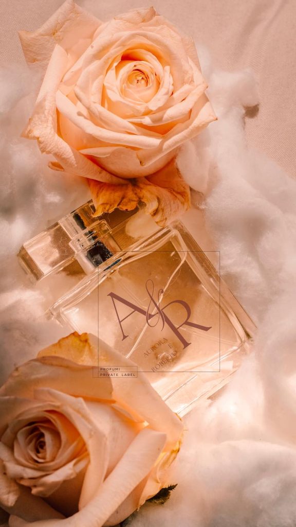In questa foto, circondata da rosze color pesca una fragranza per il matrimonio di Profumi Private Label con le iniziali della coppia