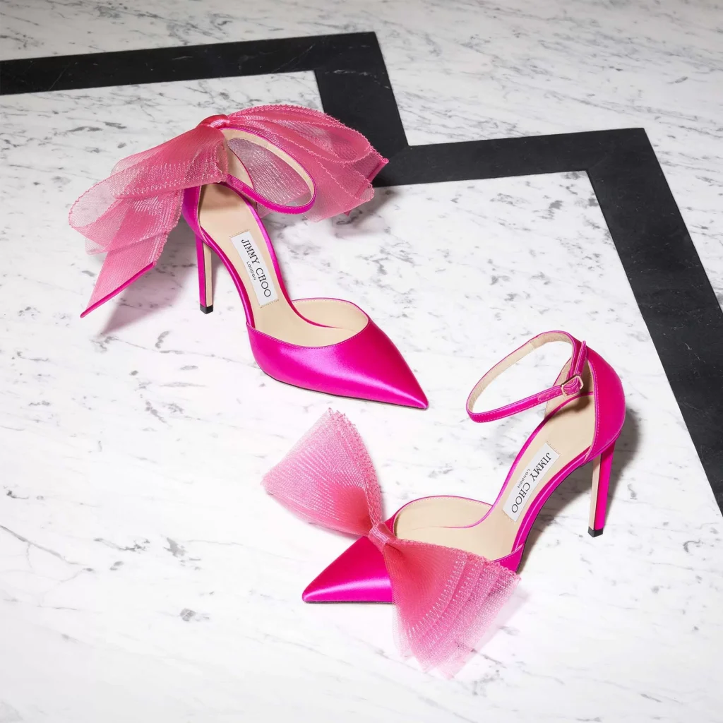 In questa foto si vede una proposta di scarpe da sposa 2026, décolleté fucsia satin con maxi fiocco in tulle sul davanti, una scelta audace e colorata per una sposa che ama distinguersi.