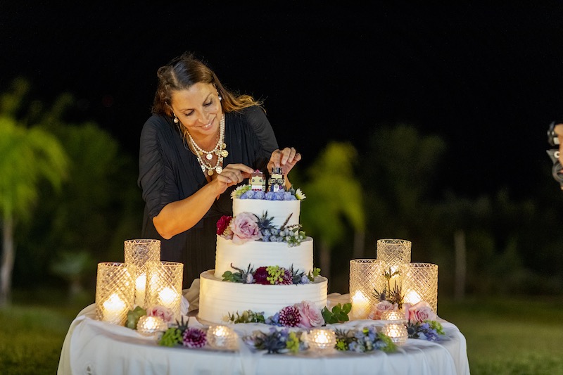 In questa foto, la Wedding Planner Luna Cianfoni mentre allestisce una torta per un matrimonio all'aperto