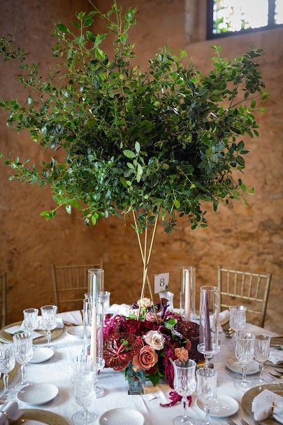 In questa foto, una mise en place per un matrimonio invernale nei toni del bordeaux, del rosso e del verde realizzato da Atelier Cianfoni