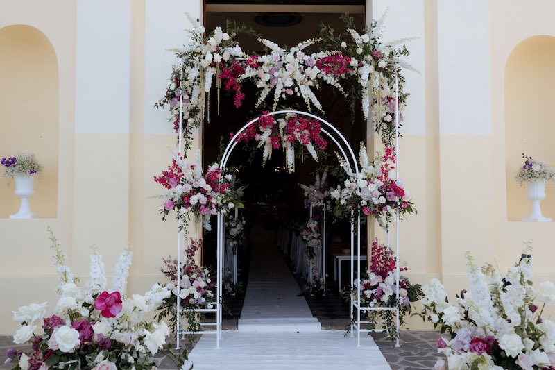 In questa foto l'ingresso della nella chiesa di San Pietro a Panarea decorato da una struttura ispirata alle luminarie della tradizione, ma interamente reinterpretata con fiori multicolor