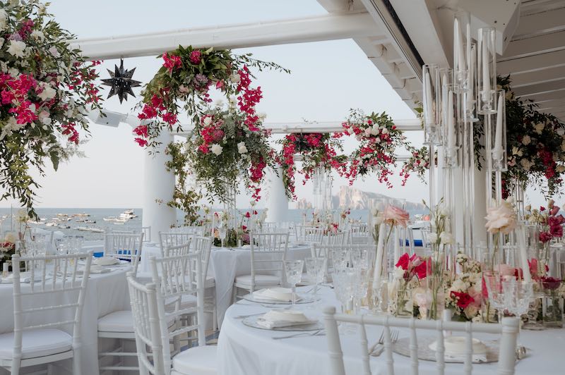 In questa foto, un ricevimento di nozze allestito in terrazza con bougainvillea, rose e candele
