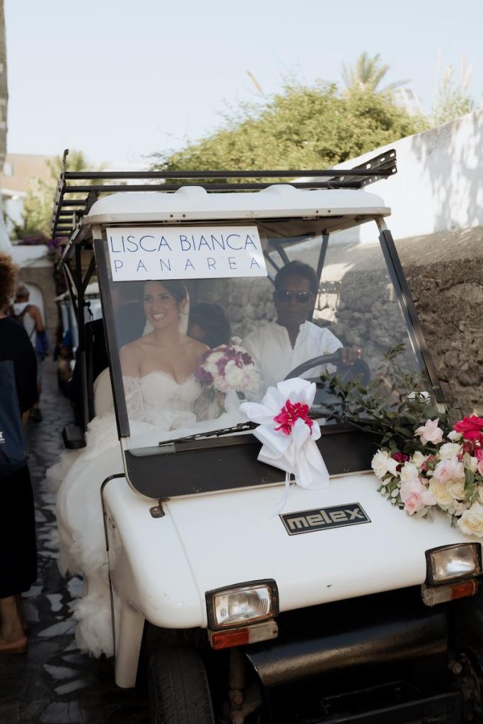 In questa foto, la sposa arriva al luogo della cerimonia con un kart del Lisca Bianca di Panarea