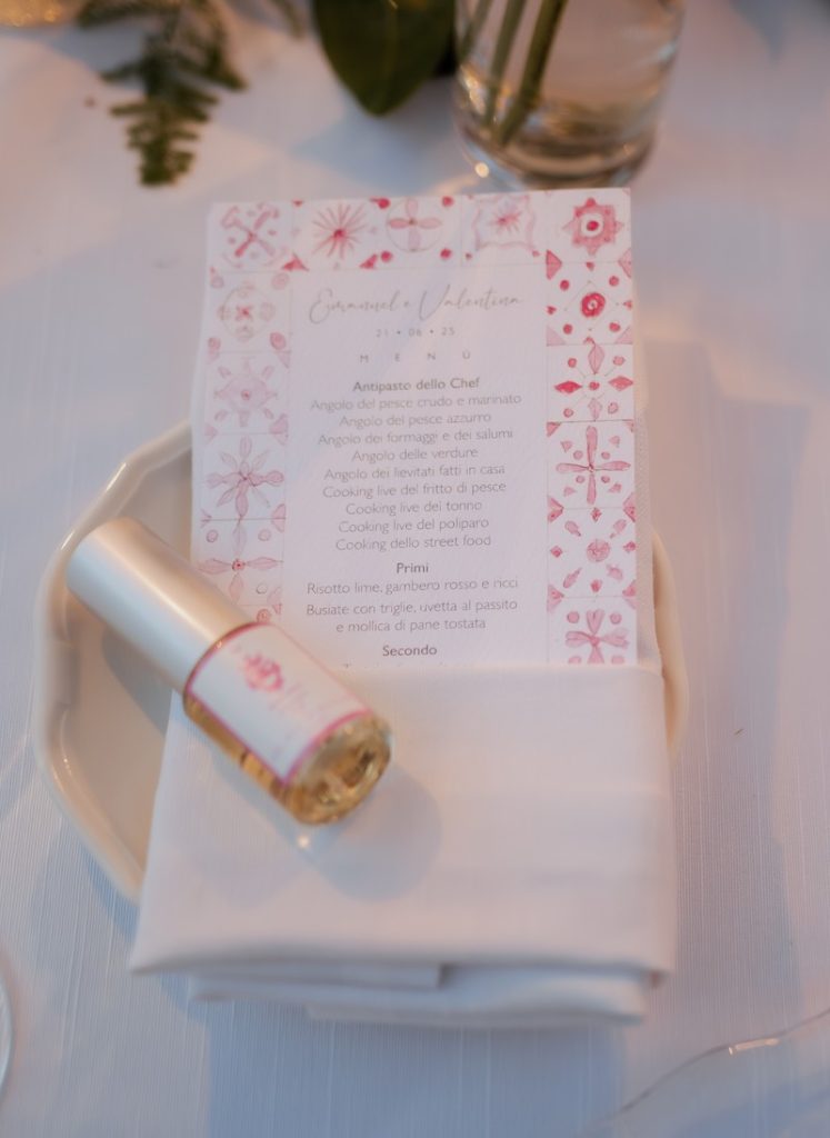 In questa foto, un di nozze con maioliche siciliane in toni di rosa affiancato ad un profumo personalizzato