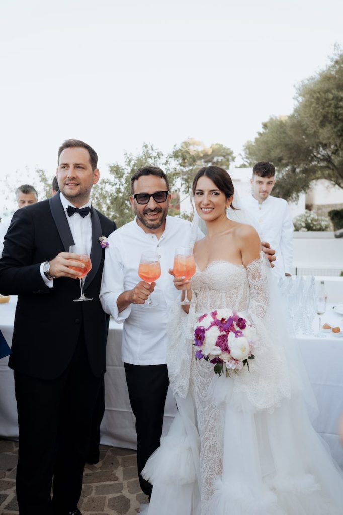 In questa foto, due sposi posano con lo chef Natale Giunta
