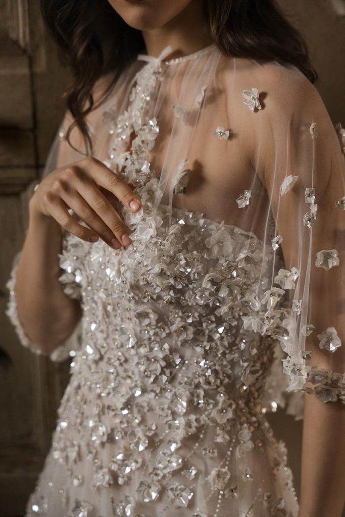 In questa foto, il dettaglio di una modella in abito da sposa con ricami di fiori 3D della collezione Legami di Donatella Gallo