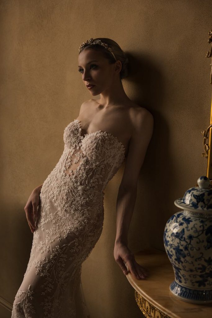 In questa foto, il dettaglio di una modella che posa indossando un abito da sposa a sirena in pizzo Donatella Gallo 2027 con scollo a cuore e interamente in pizzo