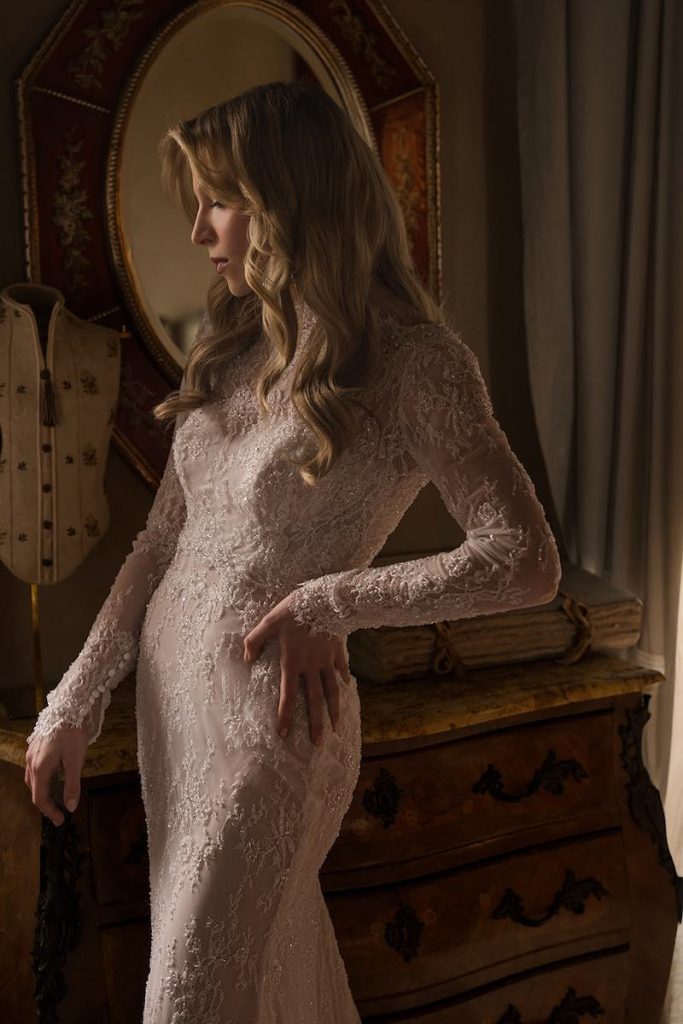 In questa foto, il dettaglio di una modella in abito da sposa in pizzo con maniche lunghe della collezione Legami di Donatella Gallo