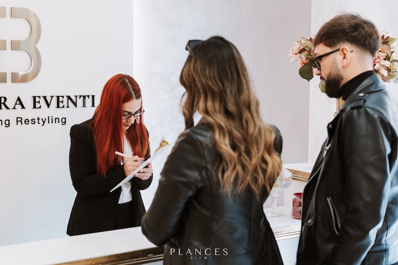 In questa foto due sposi di spalle in attesa alla reception dell'agenzia Barbara Eventi.