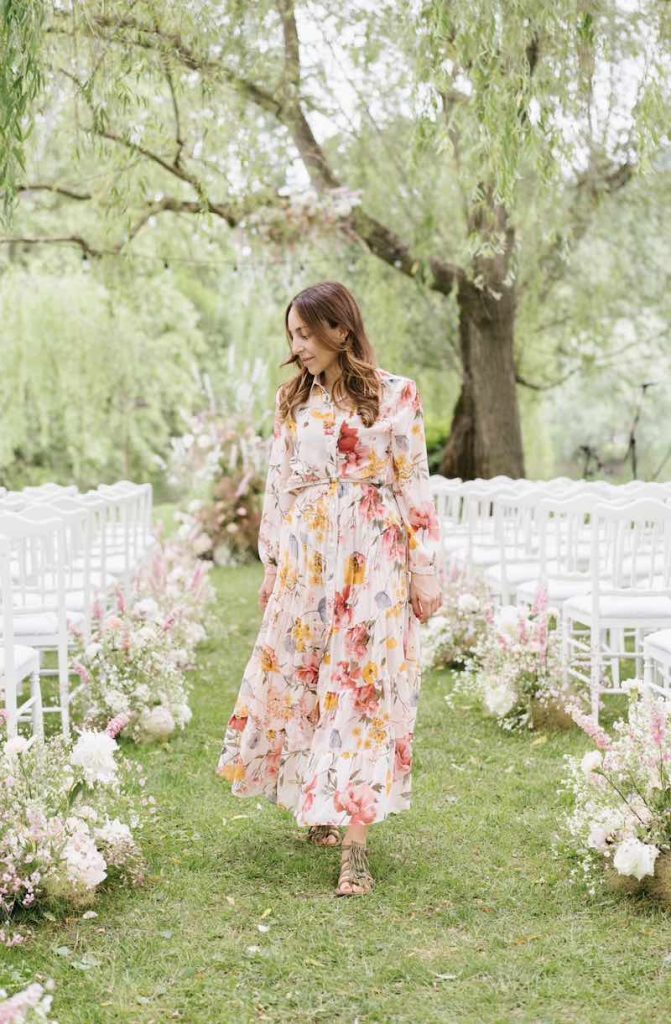 In questa foto, Nunzia Apicella founder di Le Papillon Event Designer mentre cammina lungo il corridoio centrale di un matrimonio all'aperto in un giardino