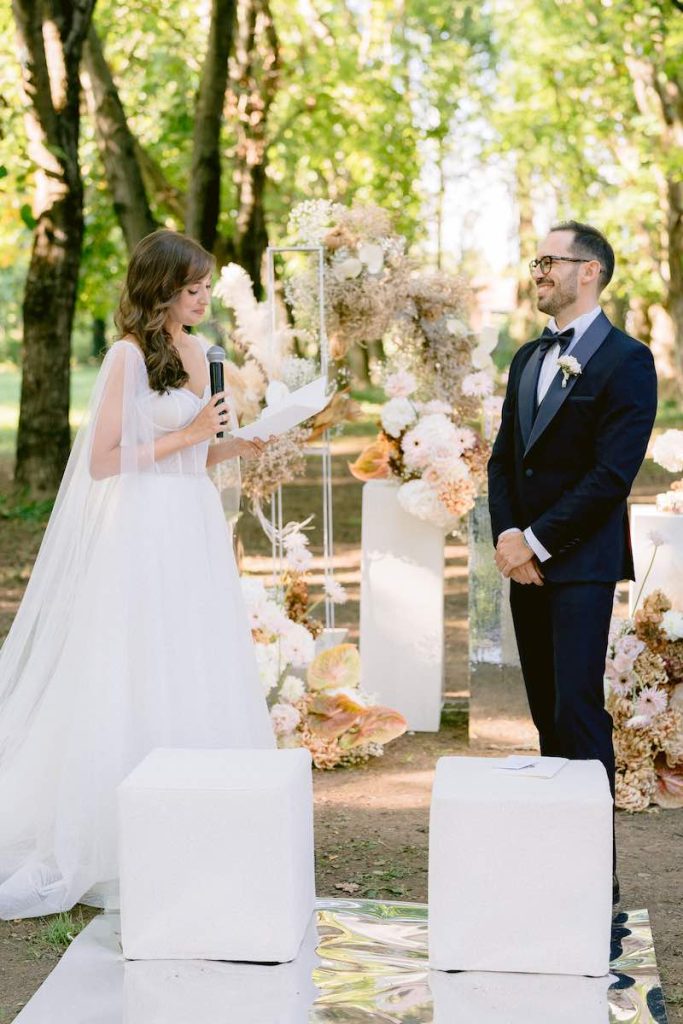 In questa foto, due sposi mentre recitano le loro promesse durante un matrimonio all'aperto