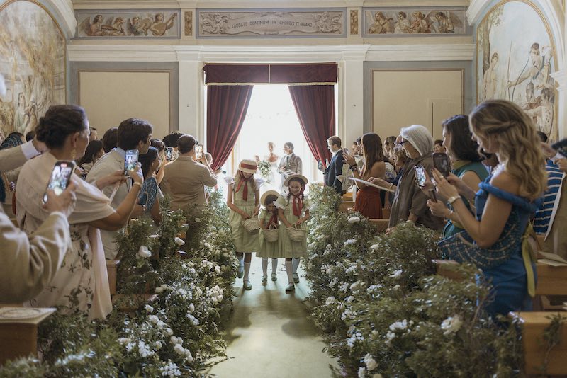 In questa foto, tre piccole flower girl entrano in chiesa anticipando l'ingresso della sposa