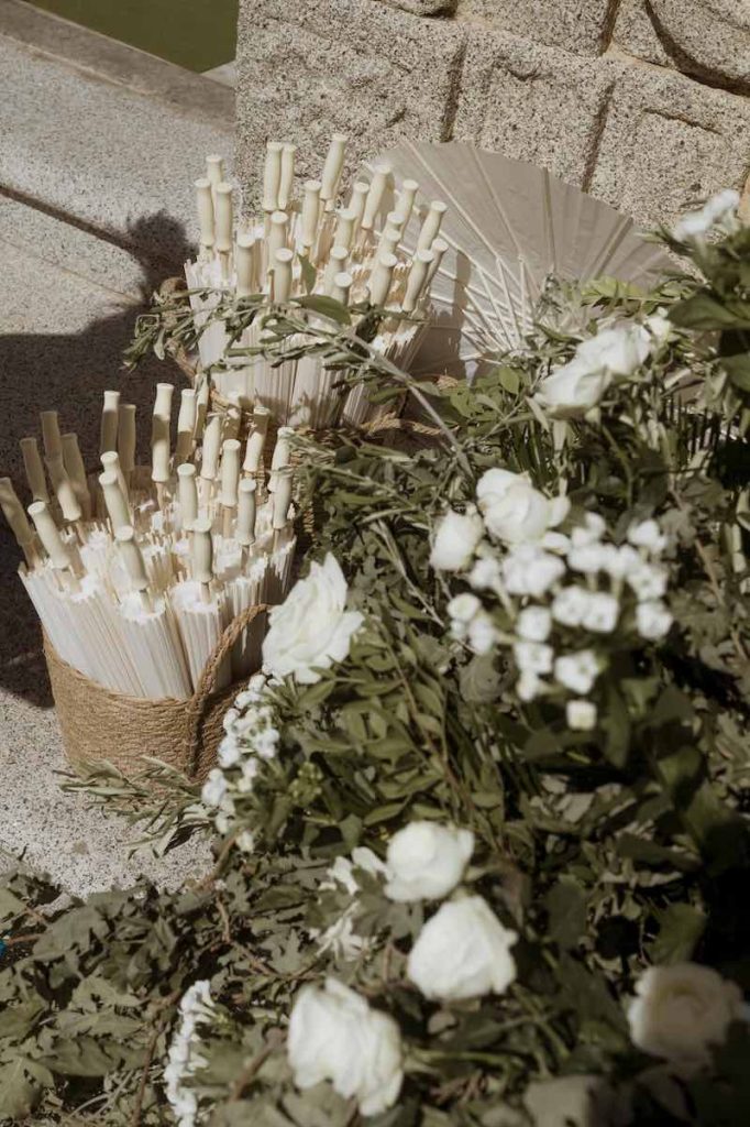 In questa foto, un dettaglio degli ombrellini e dei fiori di colore bianco posti all'ingresso della chiesa della cerimonia del matrimonio di Camilla e Niccolò