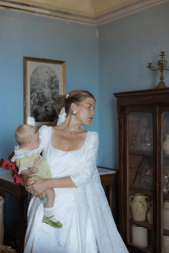 In questa foto, la sposa Camilla con in braccio la sua bambina