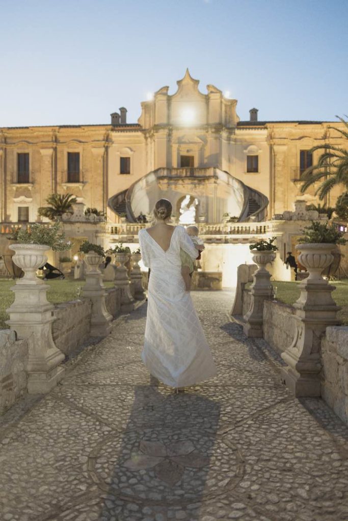 In questa foto la sposa di spalle davanti alla facciata di Villa Caristo