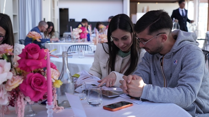 Una coppia partecipante mentre sfoglia una brochure durante "Save The Wedding"