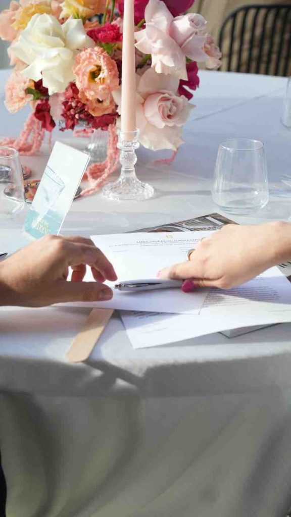 Le mani di una coppia mentre scrive durante l’evento "Save The Wedding"
