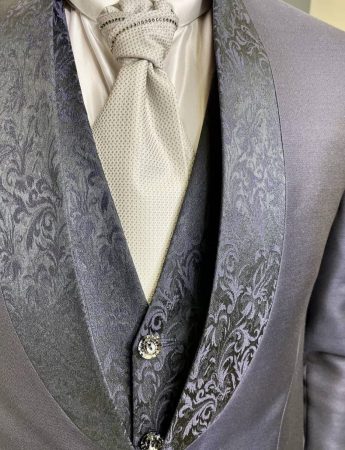 In questa foto un dettaglio di un bellissimo abito da sposo con decori damasco dai toni del blu con accessori grigio perla