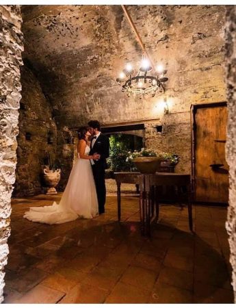 In questa foto due sposi posano in un ambiente dal gusto rustico della Casa del Grecale