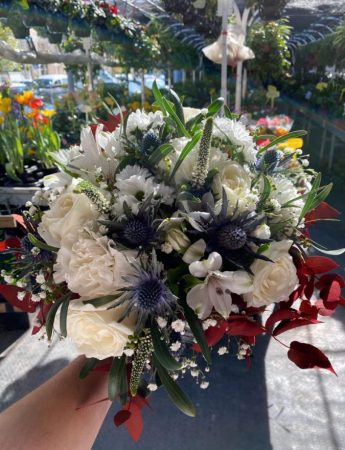 In questa foto un bouquet di nozze con fiori bianchi e viola