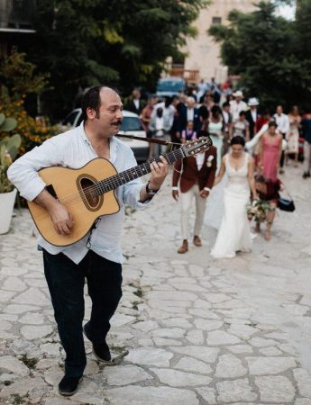 Il gruppo con una chitarra accompagna gli sposi per le strade del paese