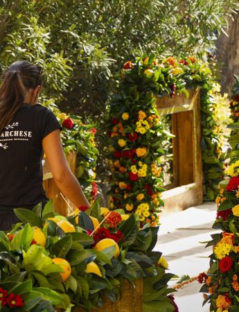 In questa foto una collaboratrice di Emilia Marchese lavora all'allestimento di un matrimonio decorato con fiori rossi e gialli